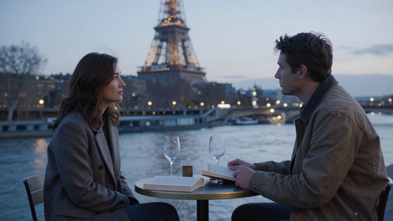 Two people sharing silent company by the Seine at dusk, with a book and wine glasses between them.